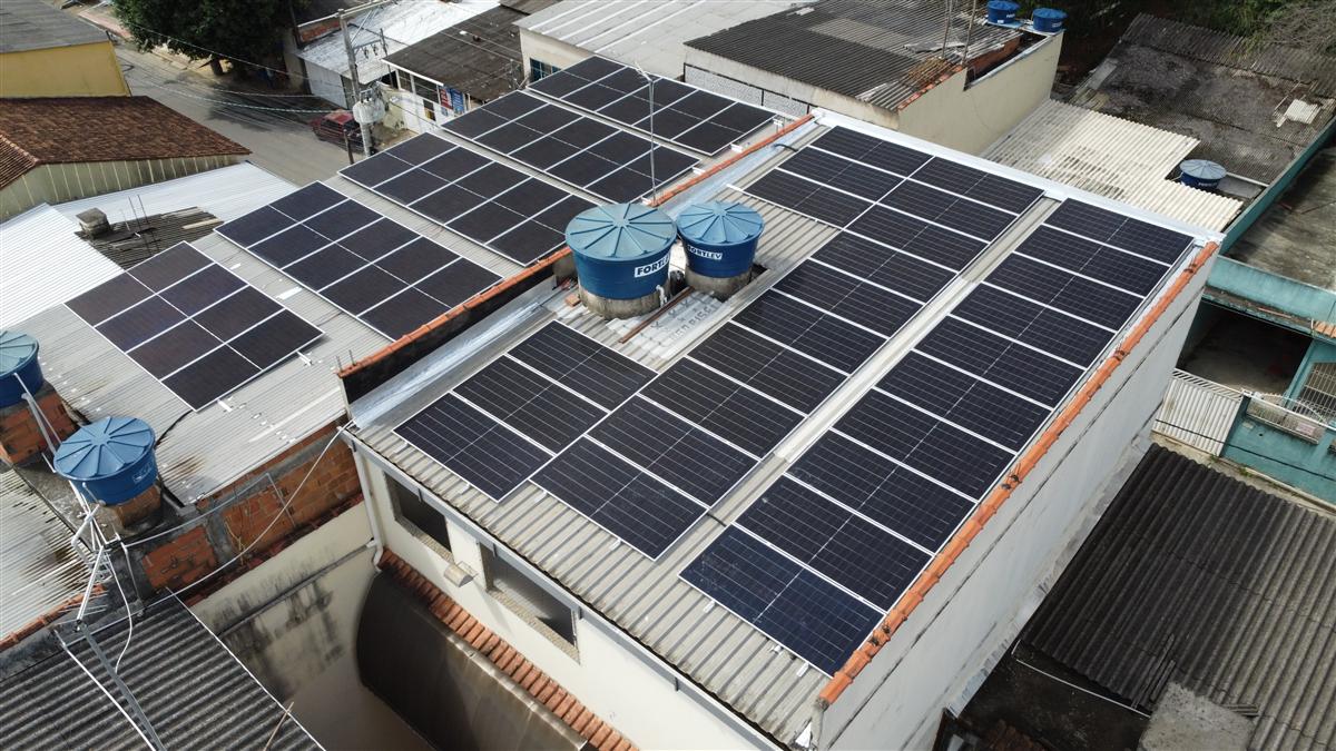 Instalação de painéis solares em telhado comercial, vista aérea